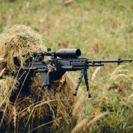 sniper in camouflage suit looking at the target