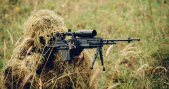 sniper in camouflage suit looking at the target